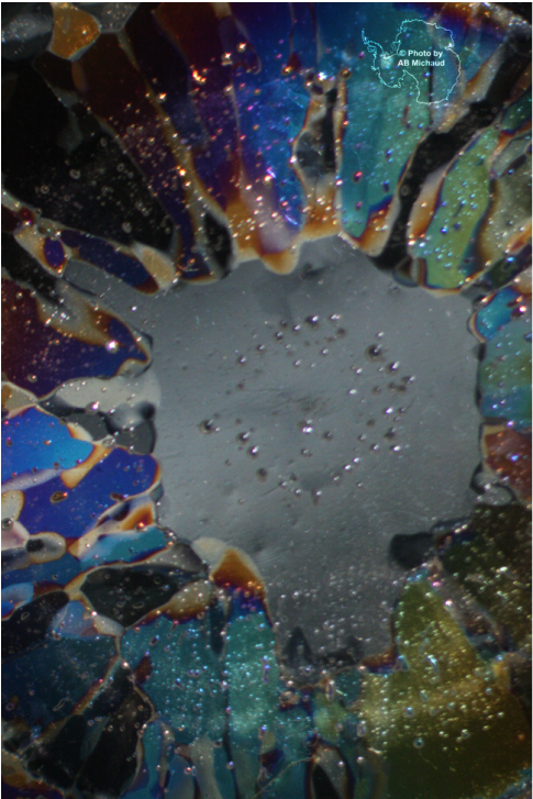 A colorful photograph of a hailstone thin-section viewed through cross-polarized light.