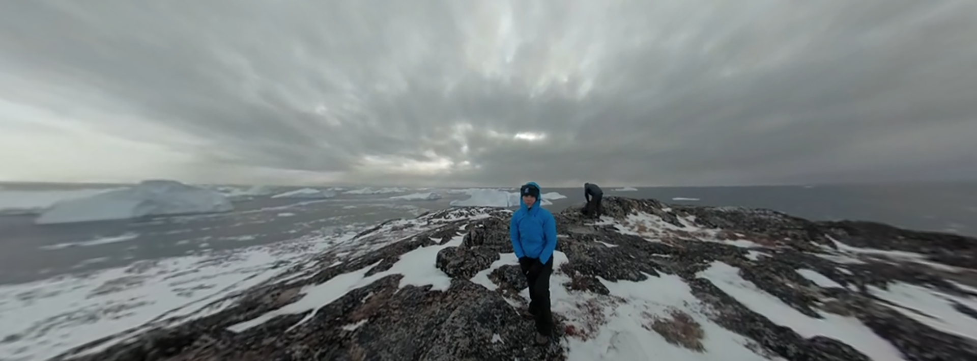 wide view of a lone researcher standing on Jakobshavn Glacier