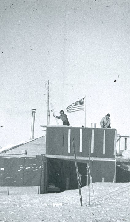 Two men on building roof in wind