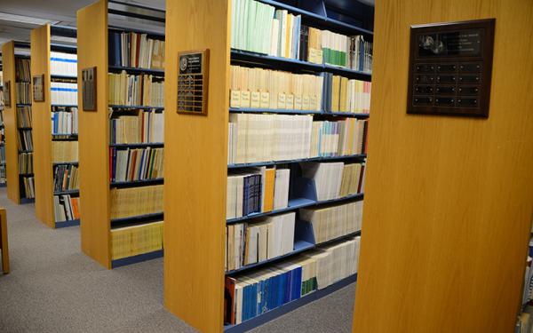 Several rows of library bookshelves filled with material