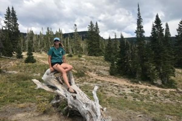 Kira Harris on a tree log