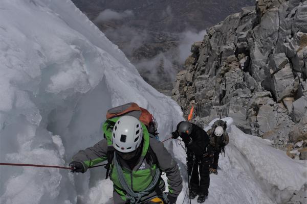Three mountaineers climbing on ice