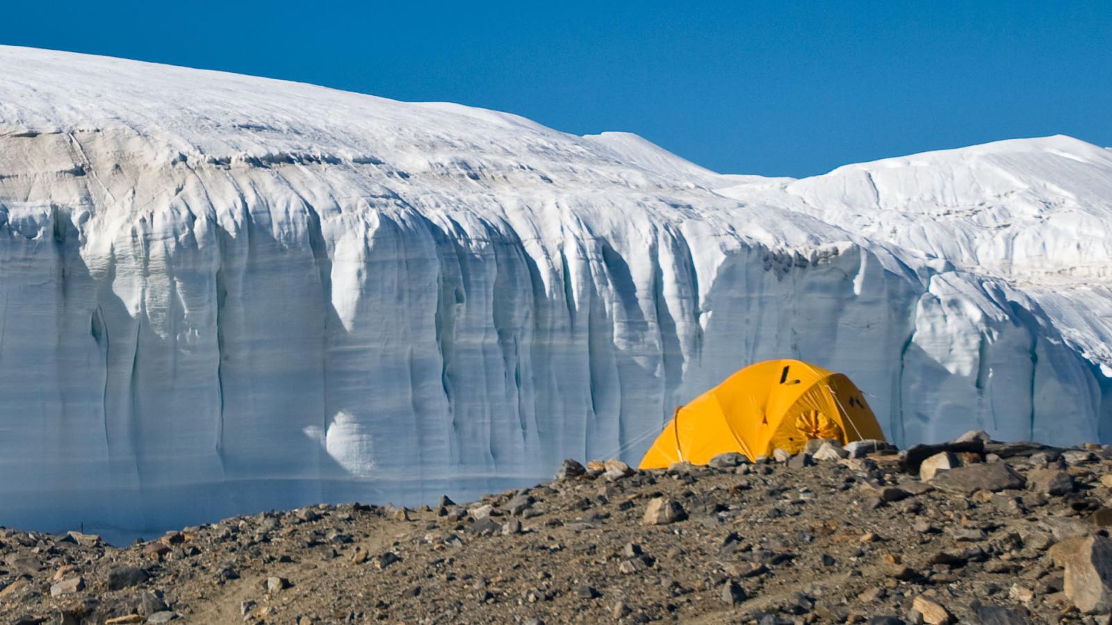 Remote Sensing Lab. A yellow tent is placed beside a large glacier